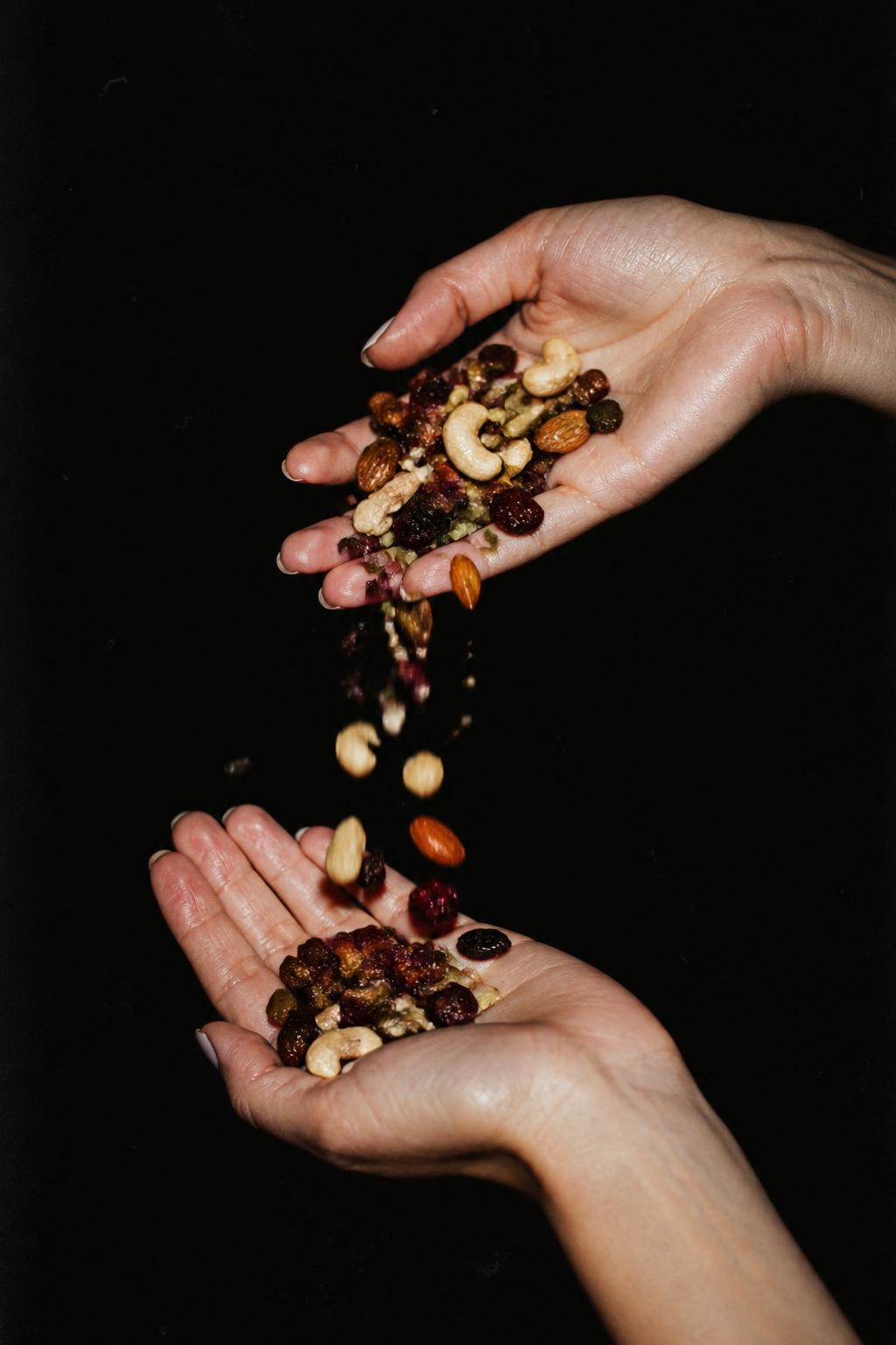 Trail mix poured into a hand on a dark background